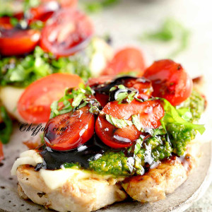 Pesto chicken bruschetta with cherry tomatoes, basil and mozzarella cheese nuts on a plate