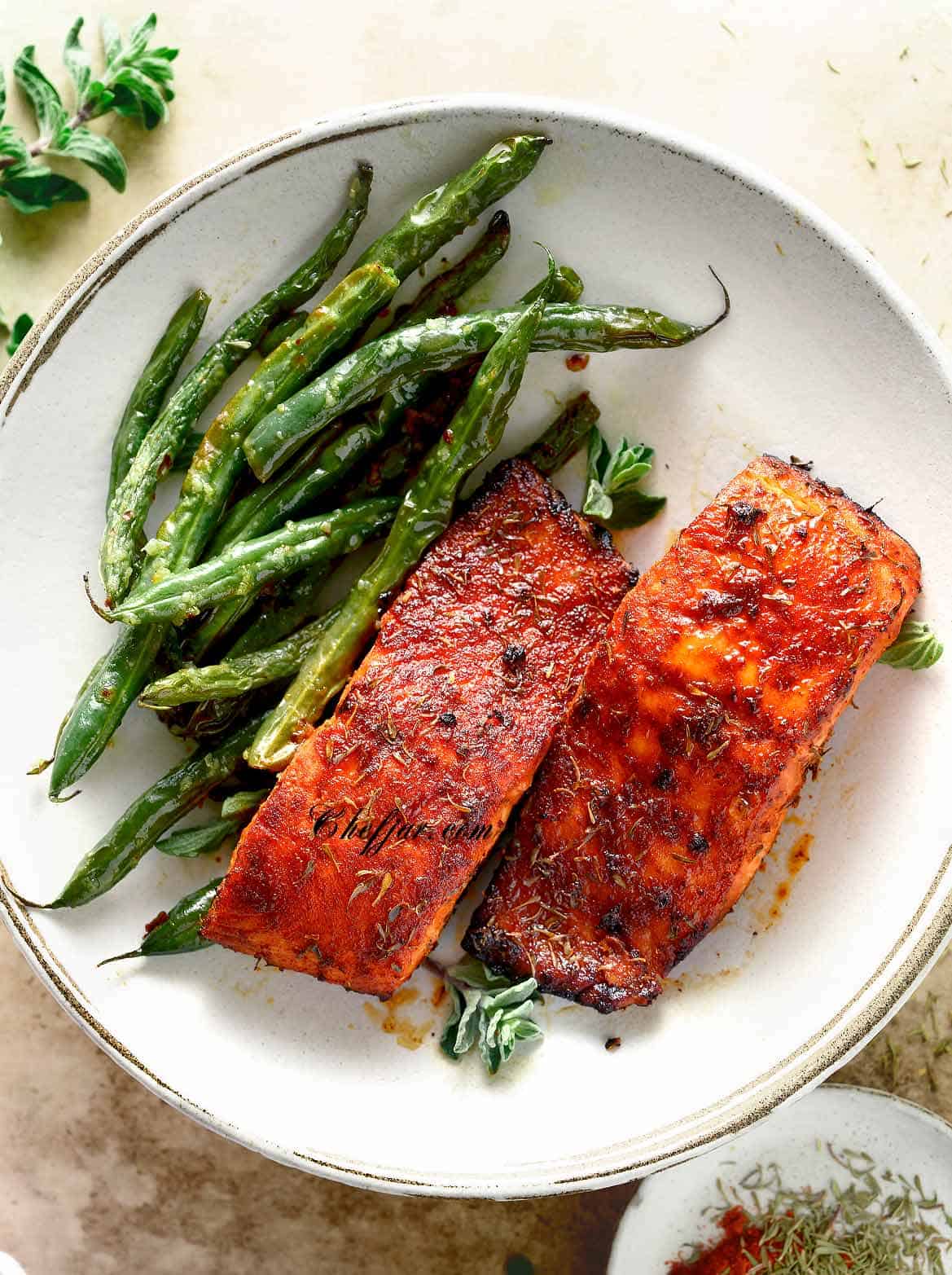 Leftover salmon on a white plate with green beans