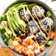 California Sushi Bowl with black sesame seeds, spicy mayo and chopsticks nearby