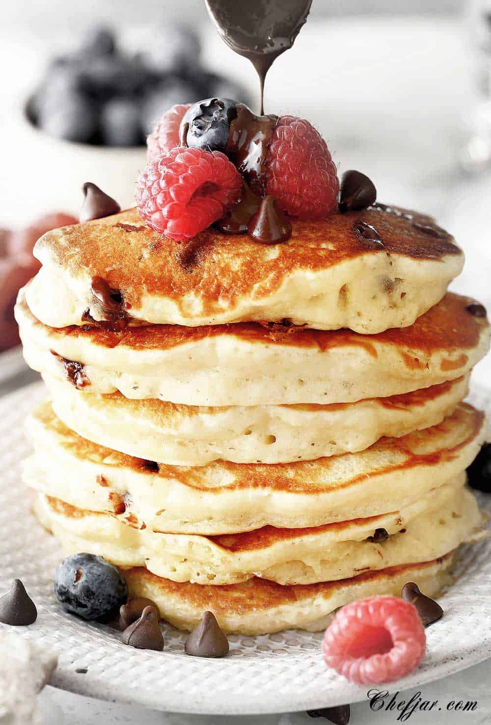 chocolate chip pancakes with berries and honey on the plate