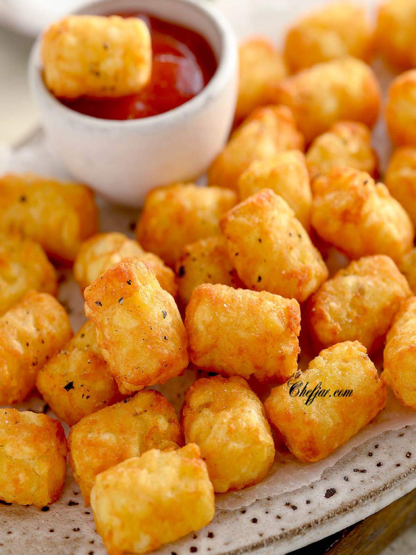 Frozen tator tots in air fryer basket (store bought frozen tater tots are air fried , often served as a side dish) with ketchup in it on the plate #airfryer #airfryerrecipes