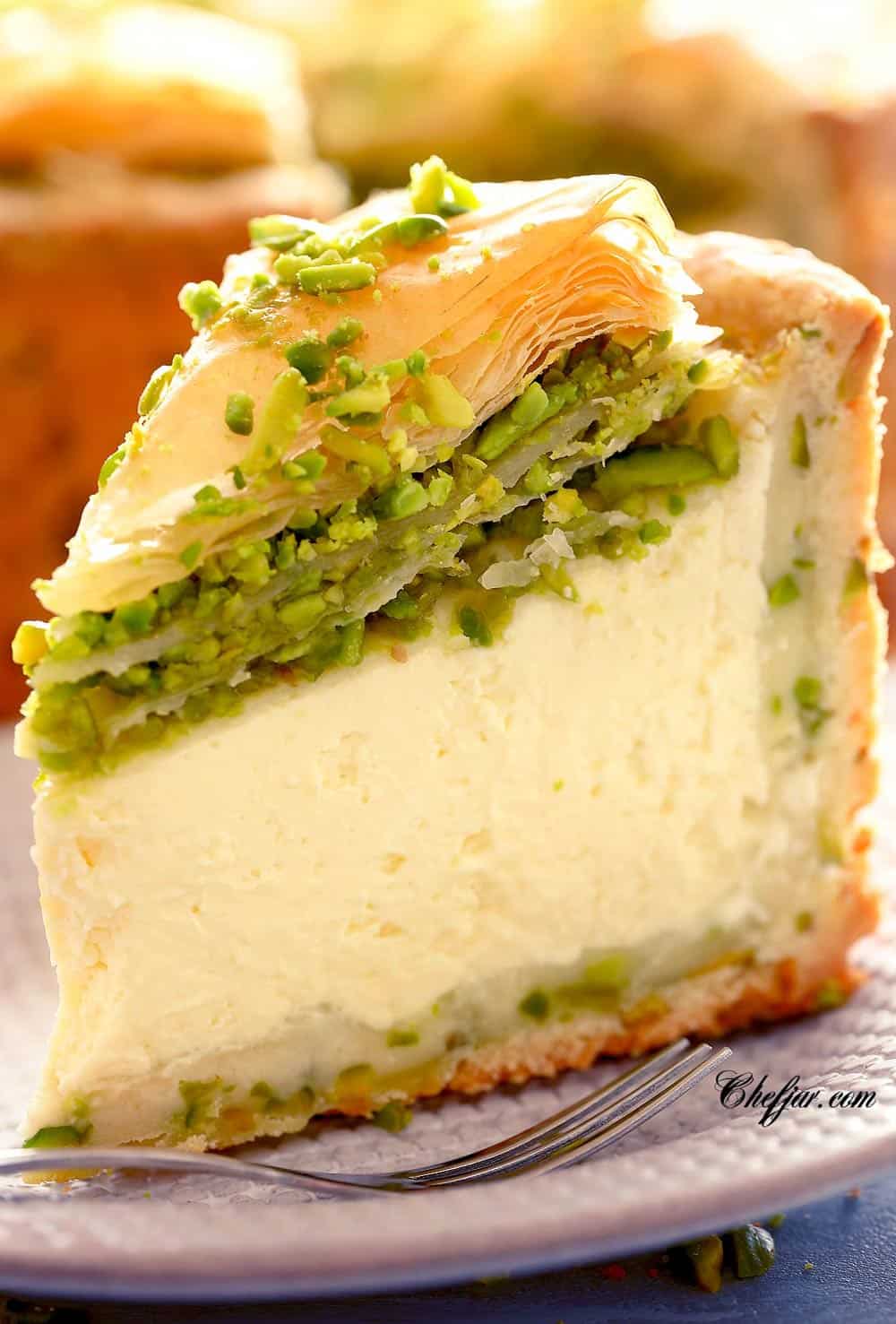 Slice of creamy cheesecake on white plate A rich, creamy, PERFECT Pistachio Baklava Cheesecake Recipe! Oh, and there's NO water bath required! #cheesecake #cheesecakerecipe #pistachiocheesecake