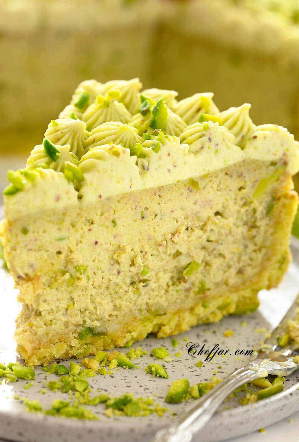 pistachio cheesecake on a plate with a fork