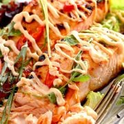 bang bang salmon on a plate. Serve it with lettuce and extra bang bang sauce.