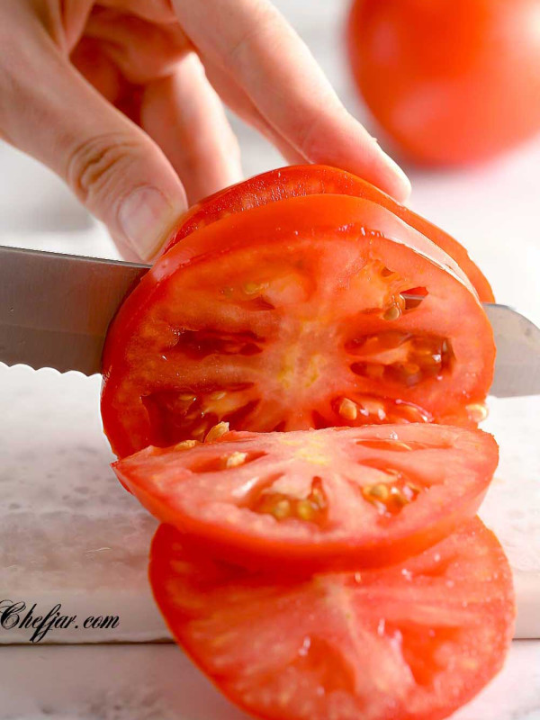 knife cutting through a tomato