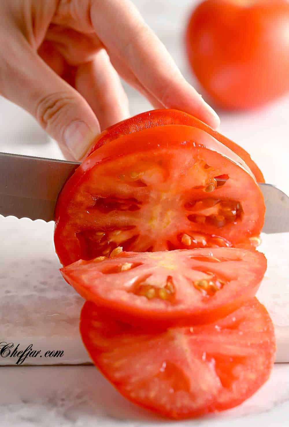 knife cutting through a tomato