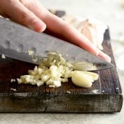 mincing garlic with large chef's knife