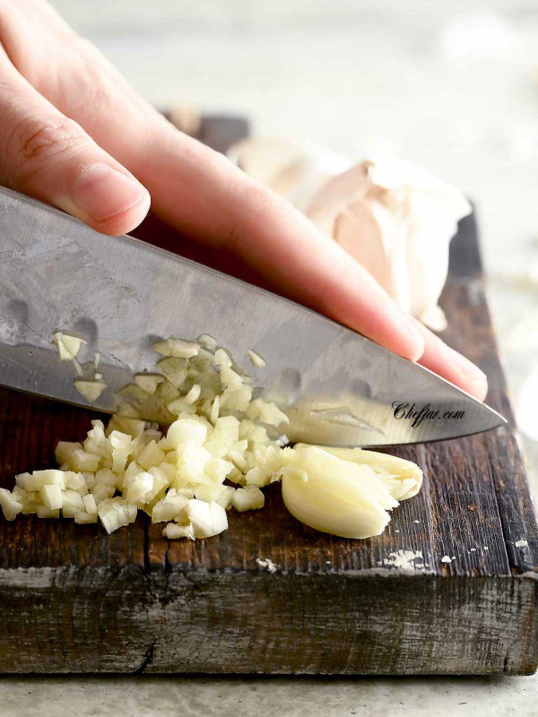 The photo shows how to cut garlic by finely mincing it