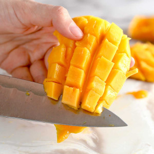 knife cutting mango cubes