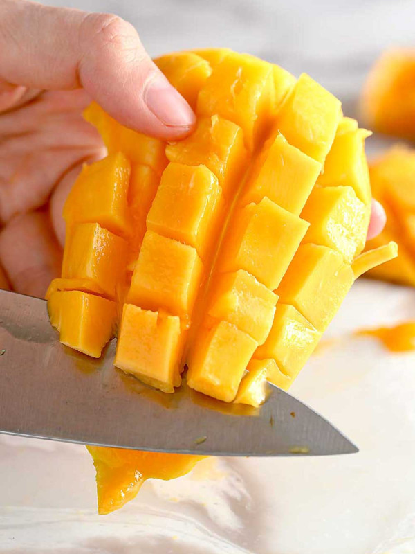 knife cutting mango cubes