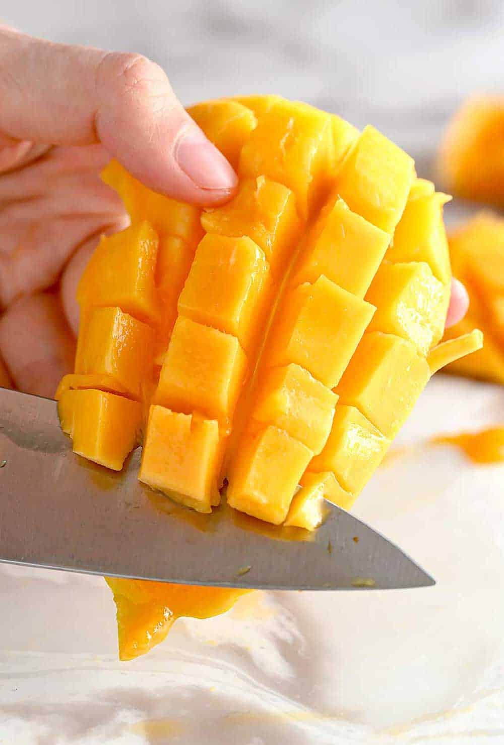 knife cutting mango cubes