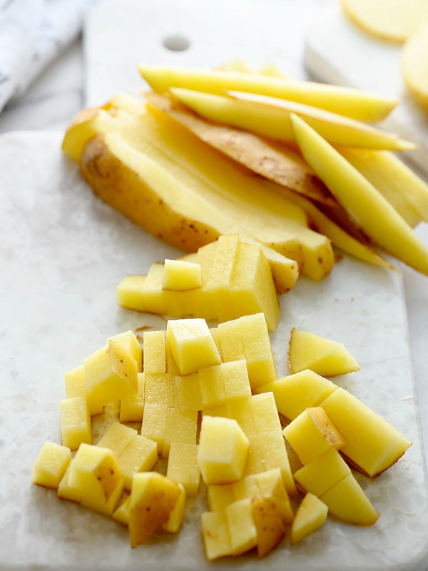 potatoes sticks and cubes on white cutting board