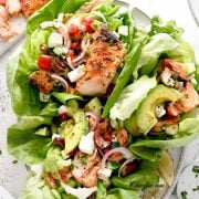 Mediterranean salmon lettuce wraps on a white plate