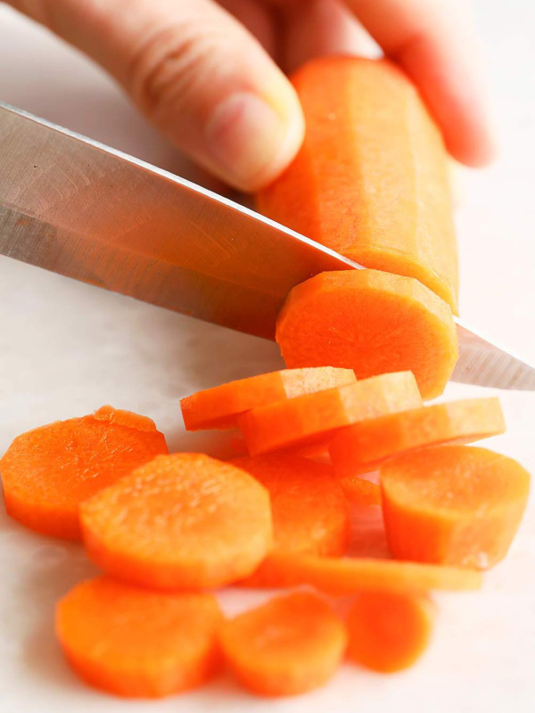 Hand cutting carrots into slices