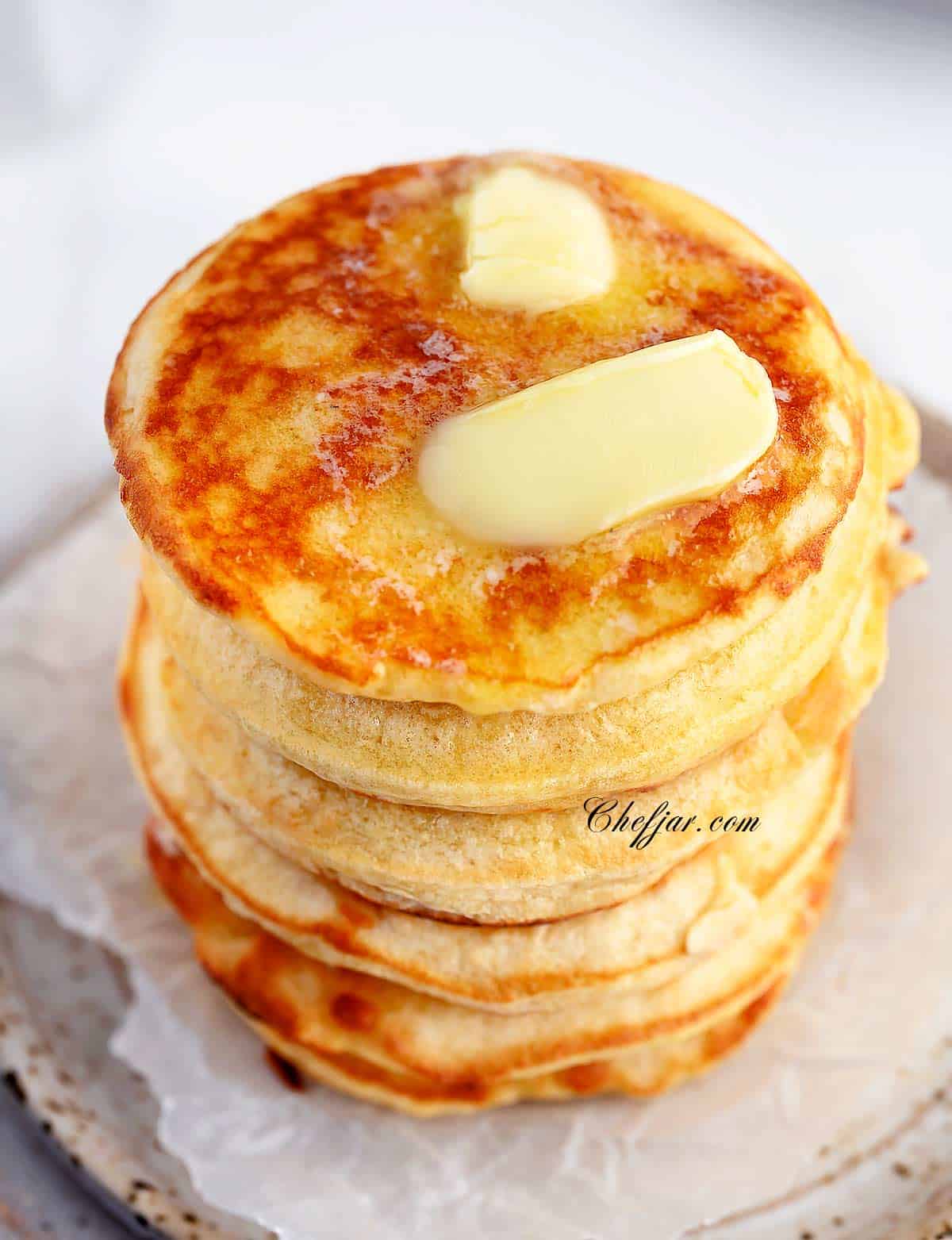 A stack of fluffy pancakes topped with butter