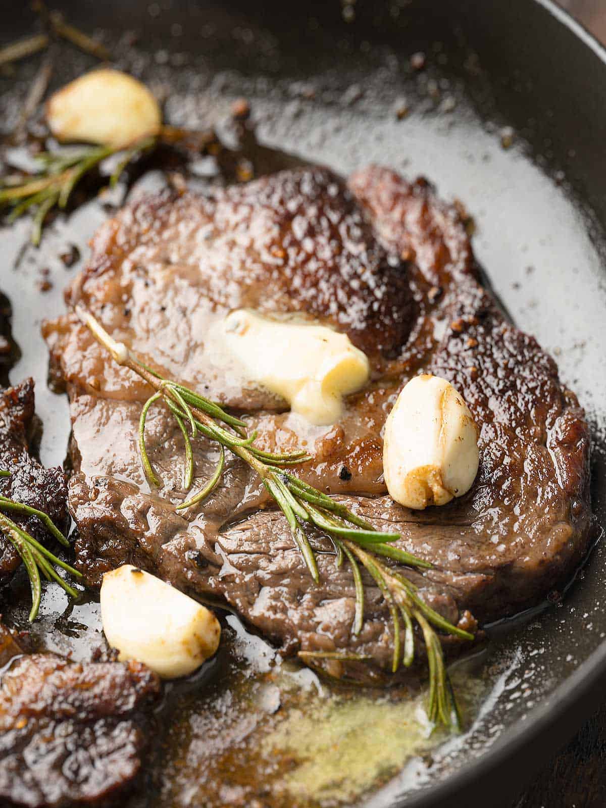 Pan seared garlic butter wagyu steaks in a  cast-iron skillet.