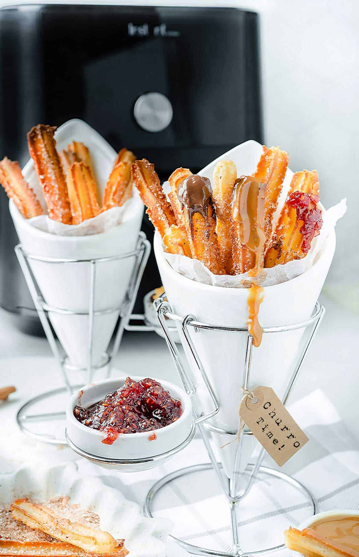 Air Fryer churros in the stand holders with Instant Vortex Air Fryer in the background.
