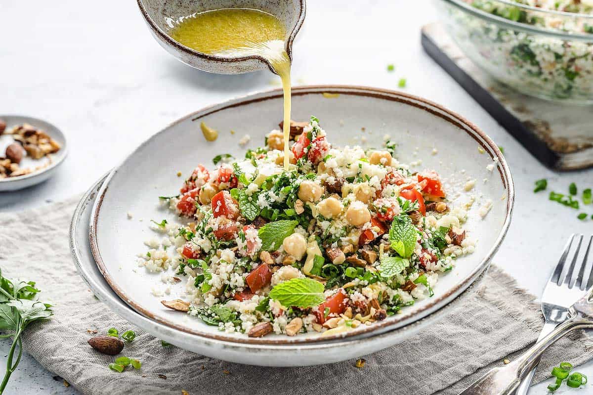 Pouring the dressing over Cauliflower Tabbouleh Salad