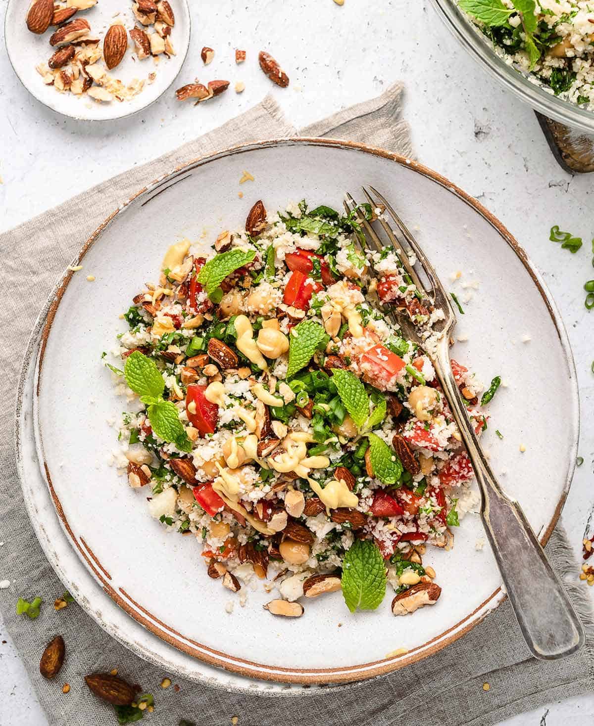 Cauliflower Tabbouleh Salad on a white plate with a fork