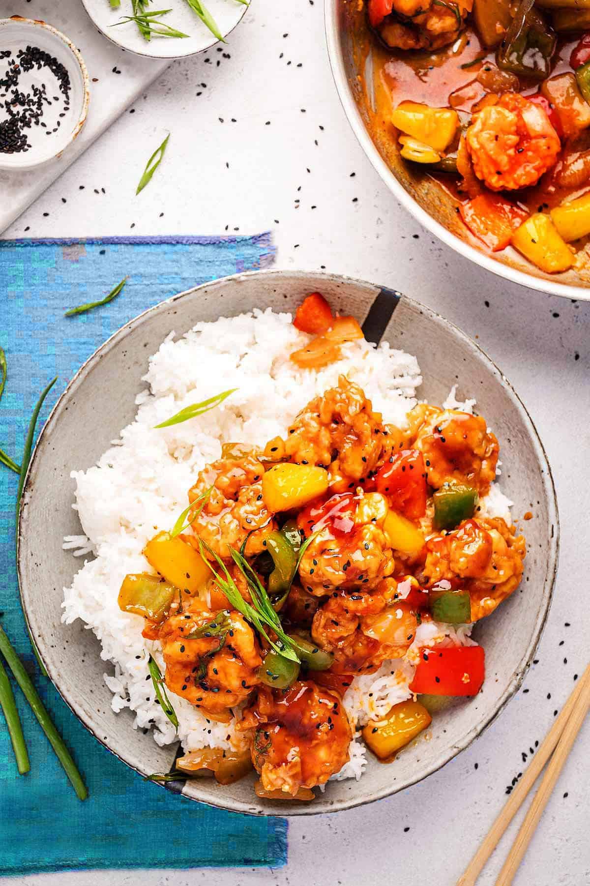 Sweet and sour prawns are served with steamed rice.