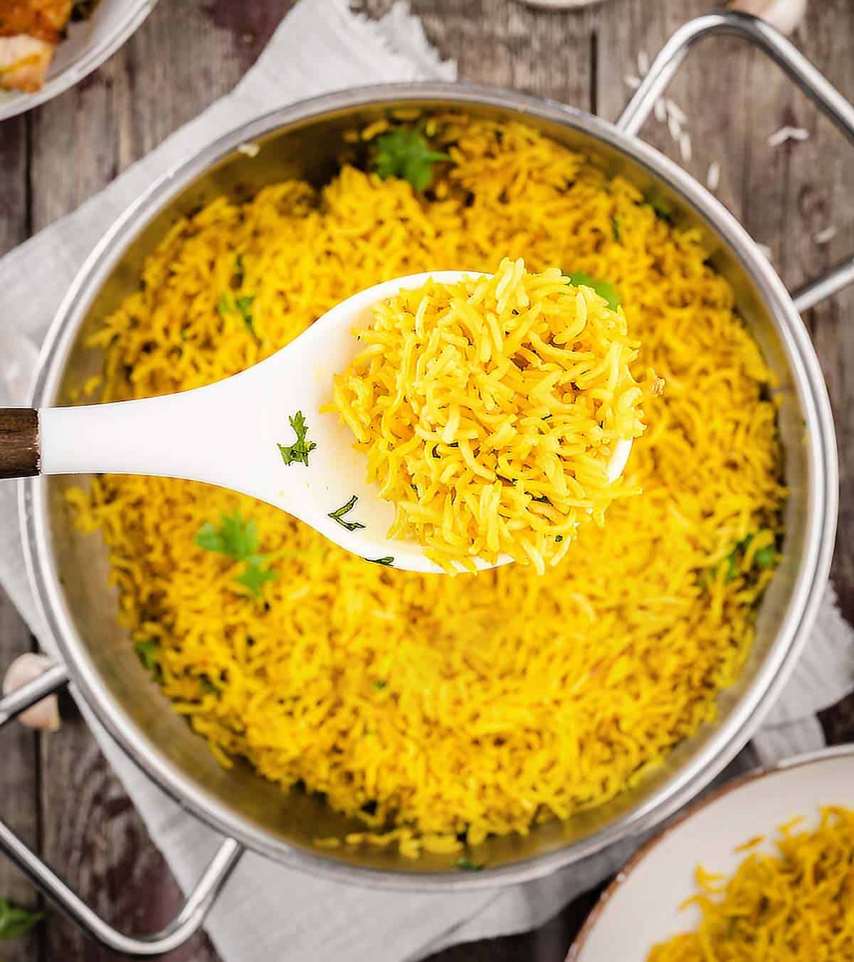 A close up shot of Turmeric Rice in a serving spoon