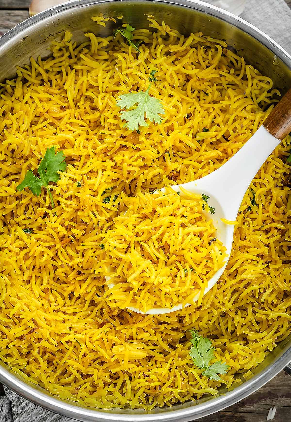 Yellow rice in a large pot with a serving spoon