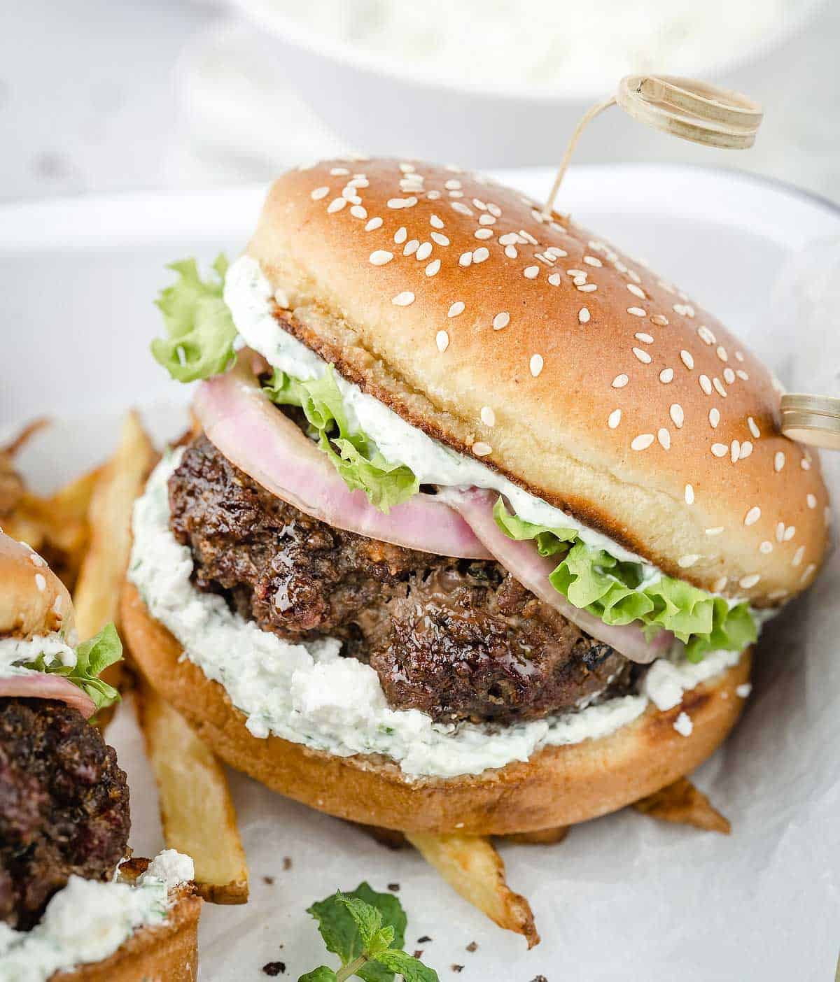Lamb burger with tzatziki and feta cheese on the serving tray