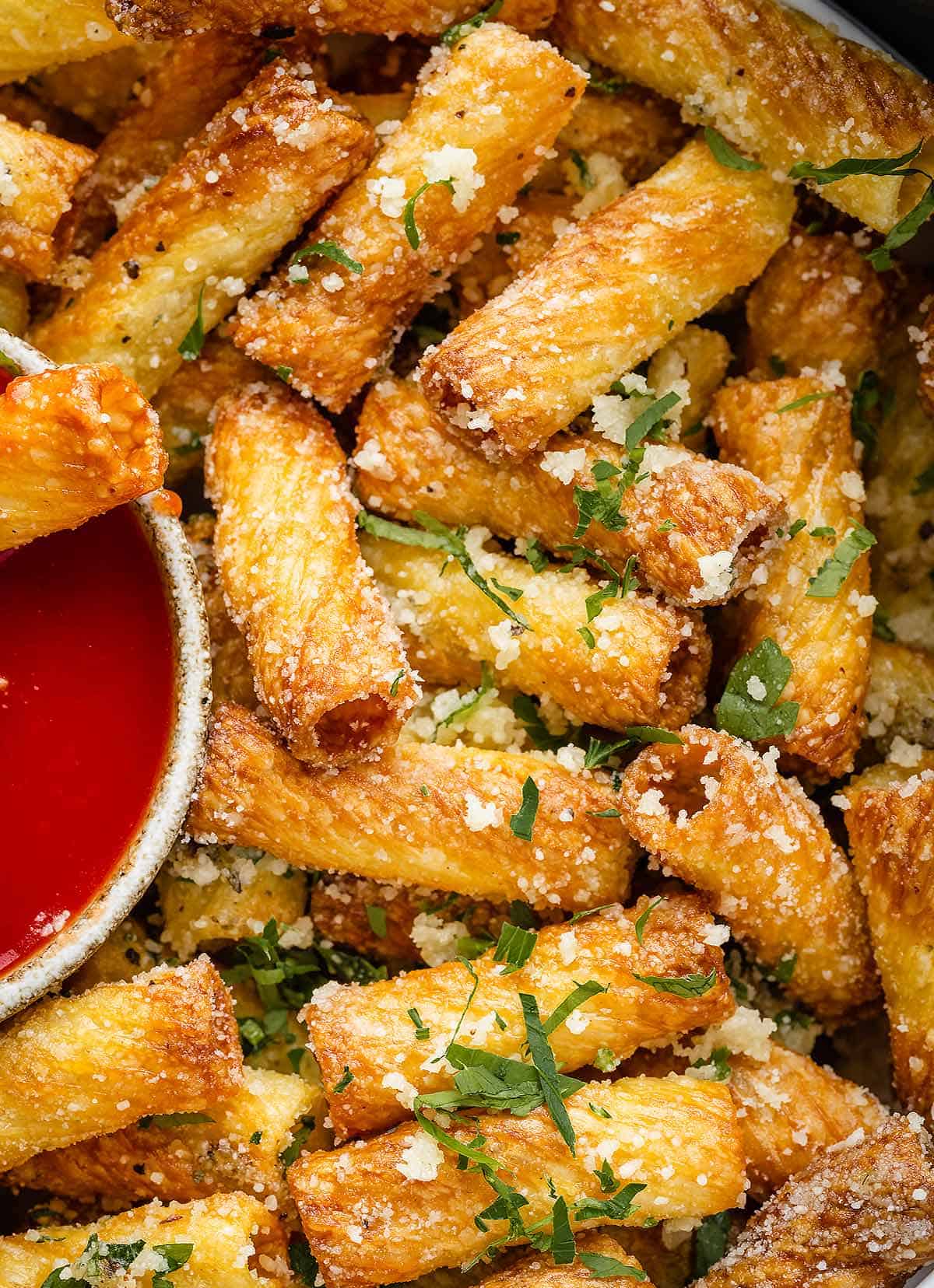 A close-up image of air fryer pasta chips served with Marinara Sauce/