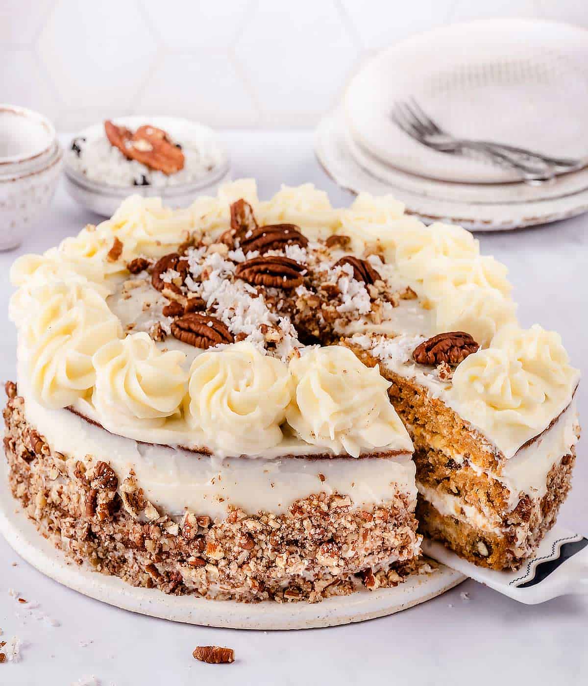 Carrot cake with cream cheese frosting on a board.