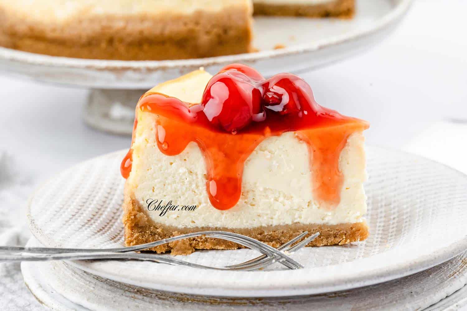 A slice of cheesecake with cherry sauce dripping down the sides. 