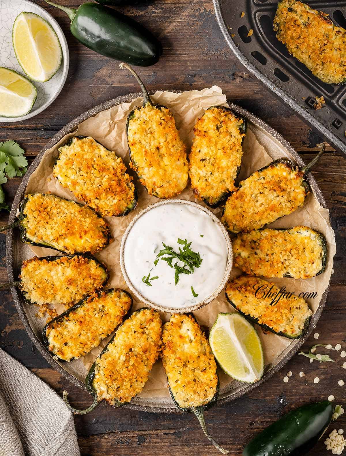 An overhead shot of Jalapeno Poppers with sour cream and lime dip.