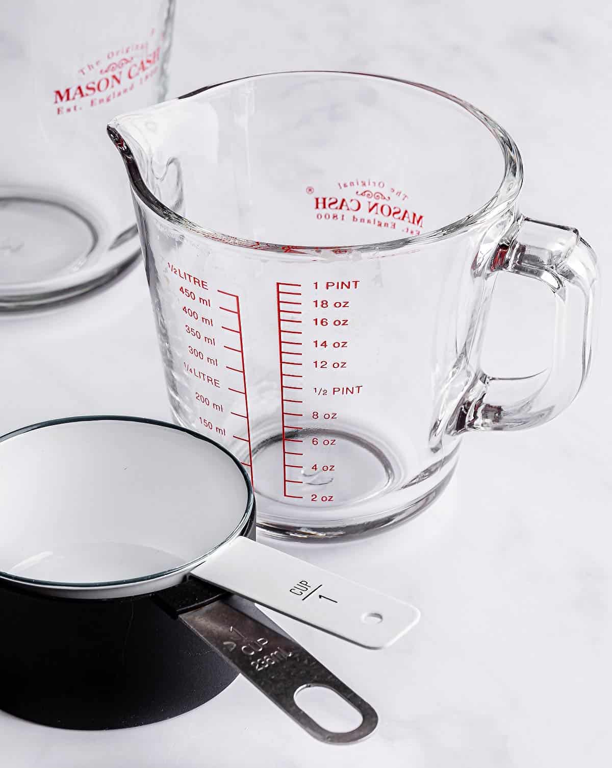 A measuring cup and two cups