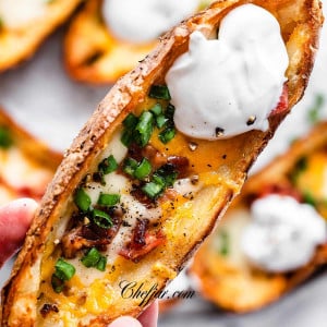 A hand holding crispy air fryer potato skin.