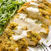 Sliced pistachio crusted chicken on plate with honey garlic sauce/ Pistachio Crusted Chicken