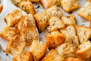 A horizontal image featuring Texas Roadhouse croutons arranged on the baking sheet, with a rustic texture and golden-brown color.