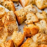 A horizontal image featuring Texas Roadhouse croutons arranged on the baking sheet, with a rustic texture and golden-brown color.