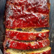 A sliced meatloaf on the wooden cutting board.