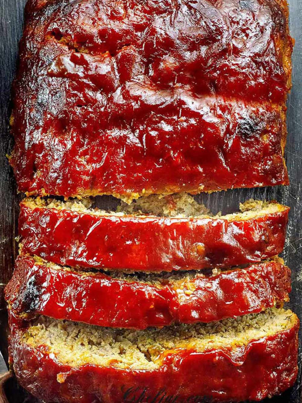 A sliced meatloaf on the wooden cutting board.