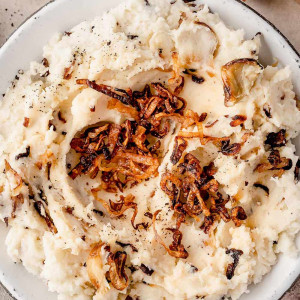 Fluffy caramelized shallot mashed potatoes served in a bowl, topped with crispy shallots.