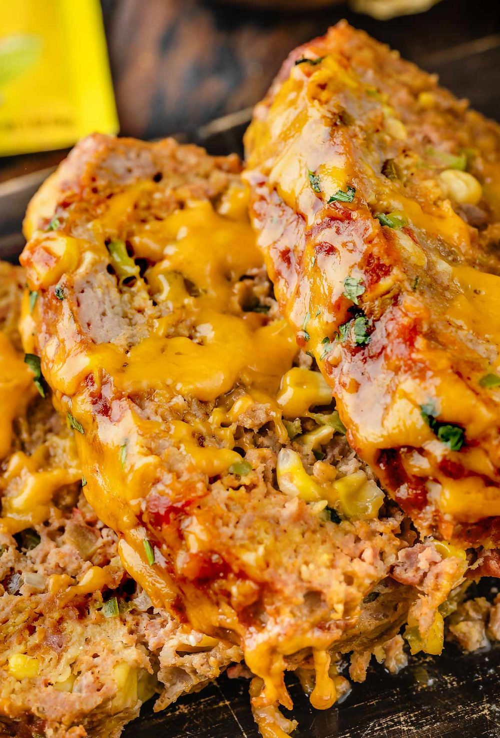 Close-up of Taco meatloaf slices with melted cheese, showcasing its delicious and cheesy texture.