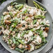 Tarragon Chicken Salad in a grey bowl: Shredded chicken mixed with asparagus, beans, nuts, and tarragon leaves, coated in a creamy dressing.