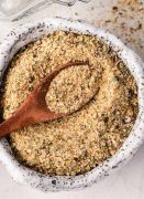 Homemade all-purpose seasoning in a small bowl with a wooden spice spoon.