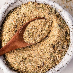 Homemade all-purpose seasoning in a small bowl with a wooden spice spoon.