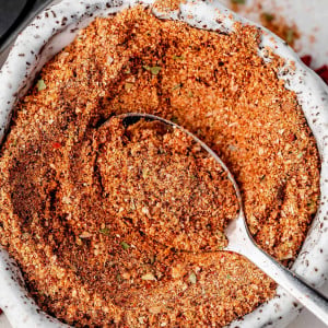 Image of Homemade Sazon Seasoning in a small bowl with a spoon.