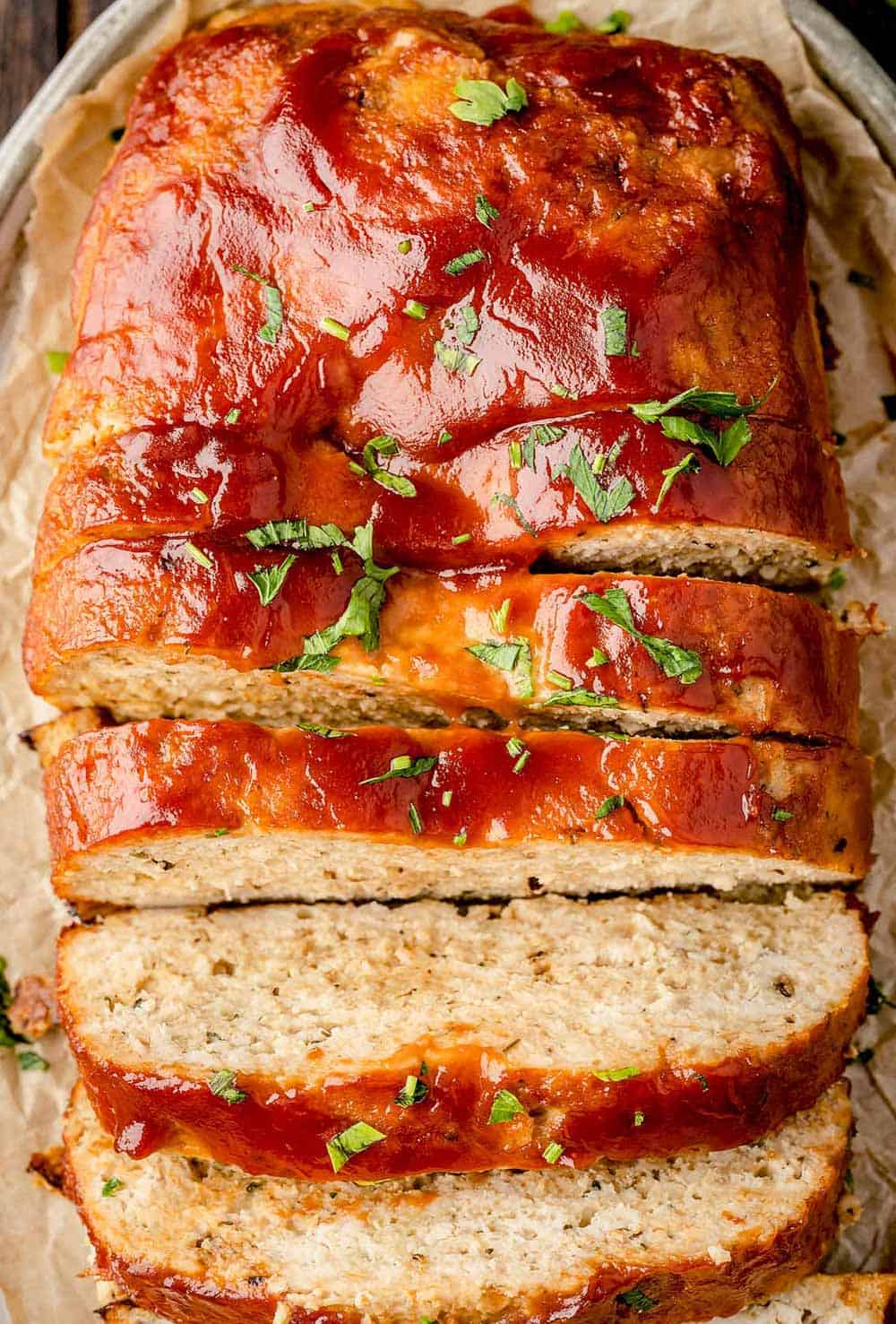 Sliced turkey meatloaf with savory herbs and spices, ready to be served.