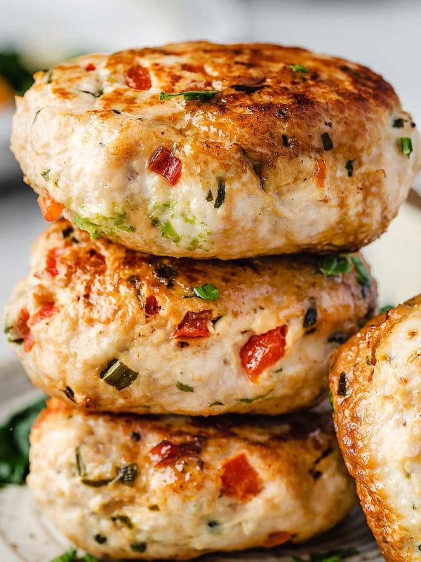 Stack of turkey patties on white plate.