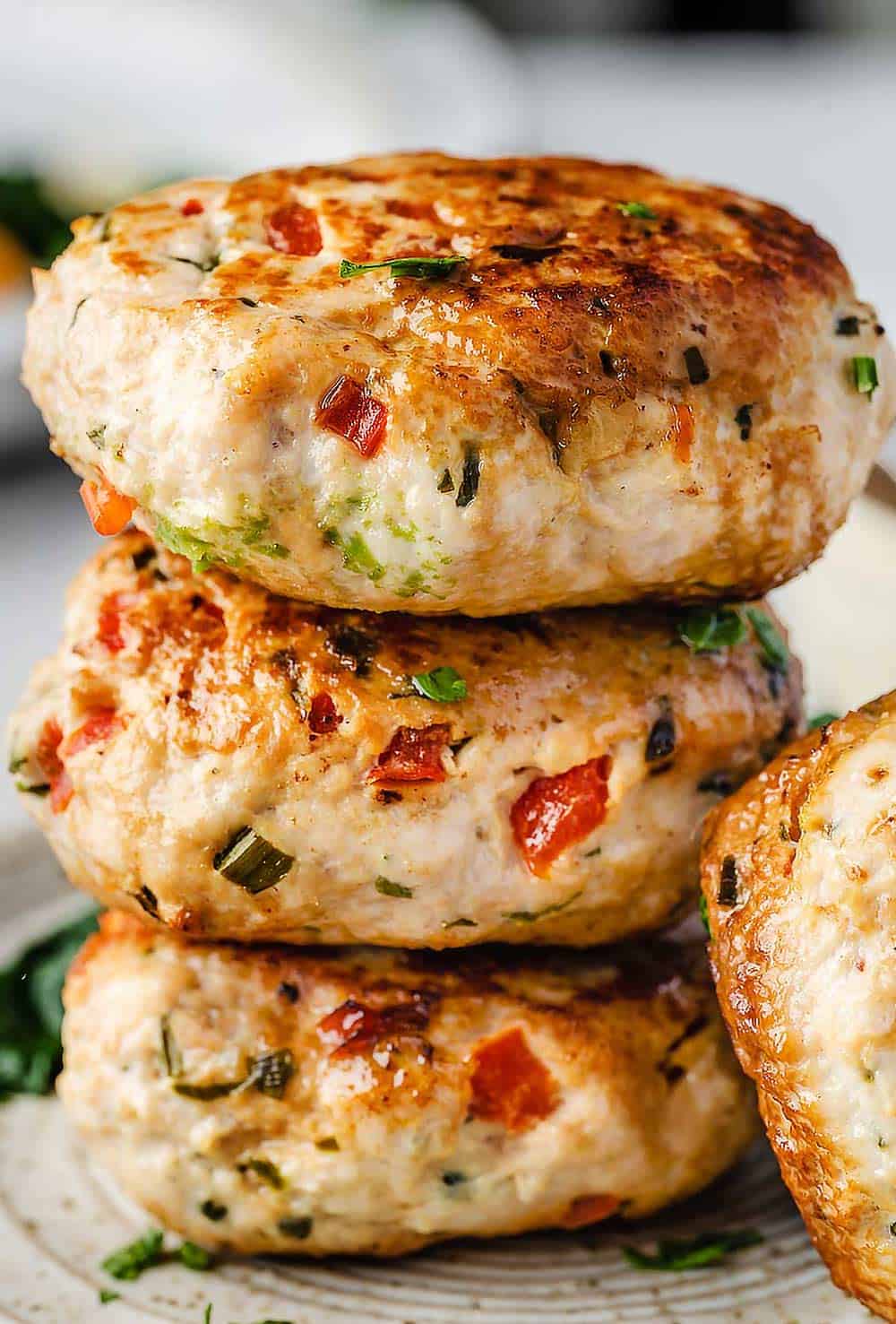 Stack of turkey patties on white plate.