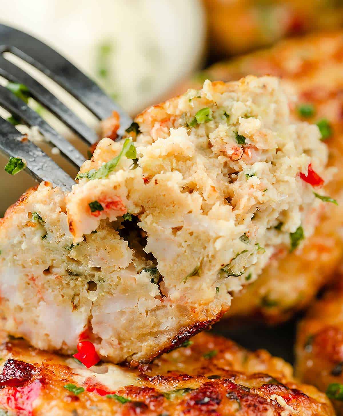 A delicious piece of shrimp cake skewered on a fork, ready to be enjoyed.