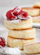 Delicious stack of cottage cheese pancakes topped with fresh raspberries and powdered sugar.