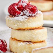 Delicious stack of cottage cheese pancakes topped with fresh raspberries and powdered sugar.